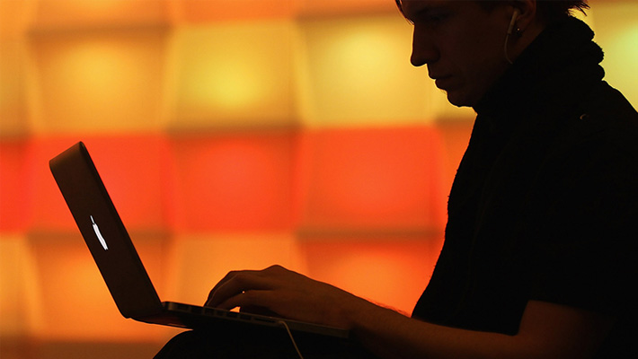 A young computer enthusiast pecks at his keyboard at a hacking competition.