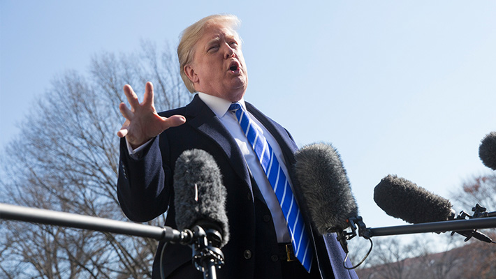 President Donald Trump talks with reporters outside the White House.