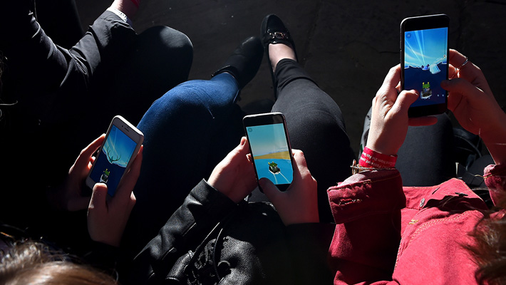 A trio of cell phone users flit through an app.