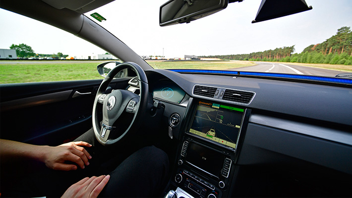 A person sits in the 'driver's seat' of an autonomous car.