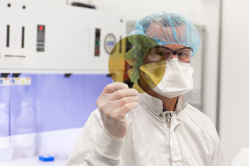 A scientist at SK Siltron CSS holds a silicon carbide wafer produced at the company's Michigan facility.