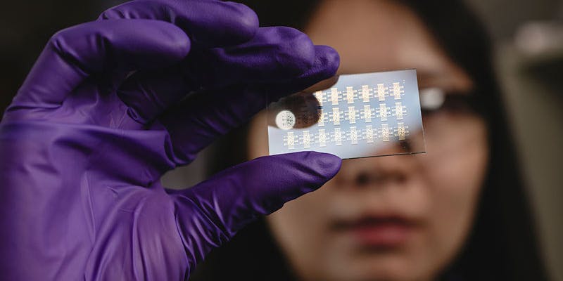 Grad student Ke Chen looks at a silicon visual sensor that uses human limitations to train computers on how to better interpret light.