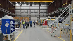 Group of men in center aisle of factory Group of men in center aisle of factory