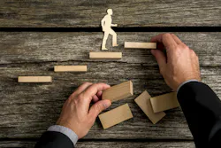 Silhouette cutouts of a man walking up steps. The hand of a businessman is building the stairs for him. Silhouette cutouts of a man walking up steps. The hand of a businessman is building the stairs for him.