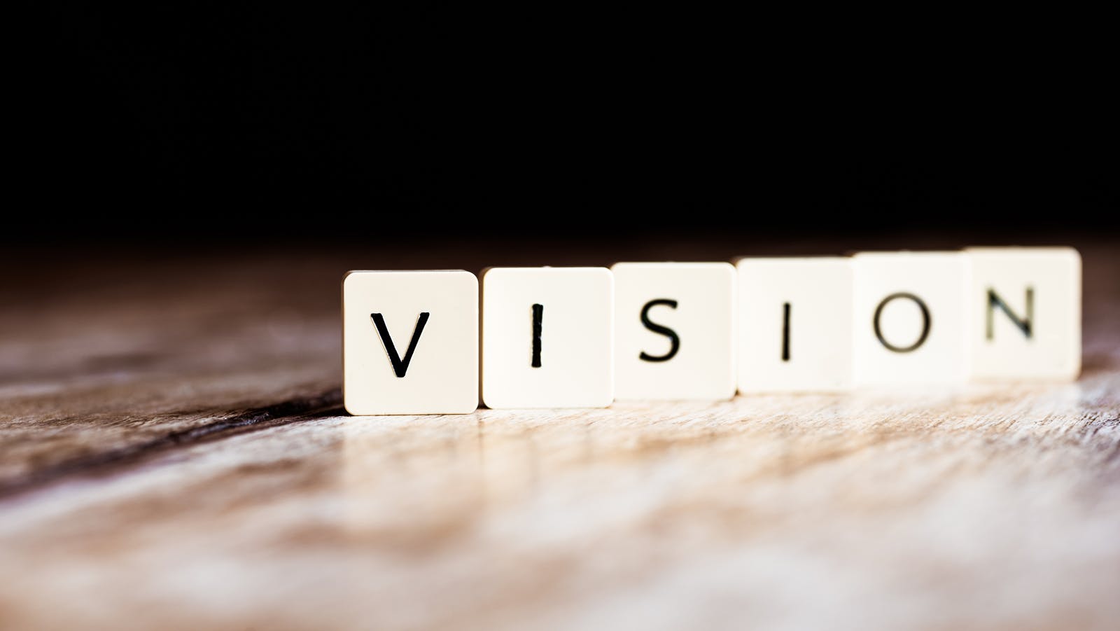 The word 'vision' in black on white tiles.