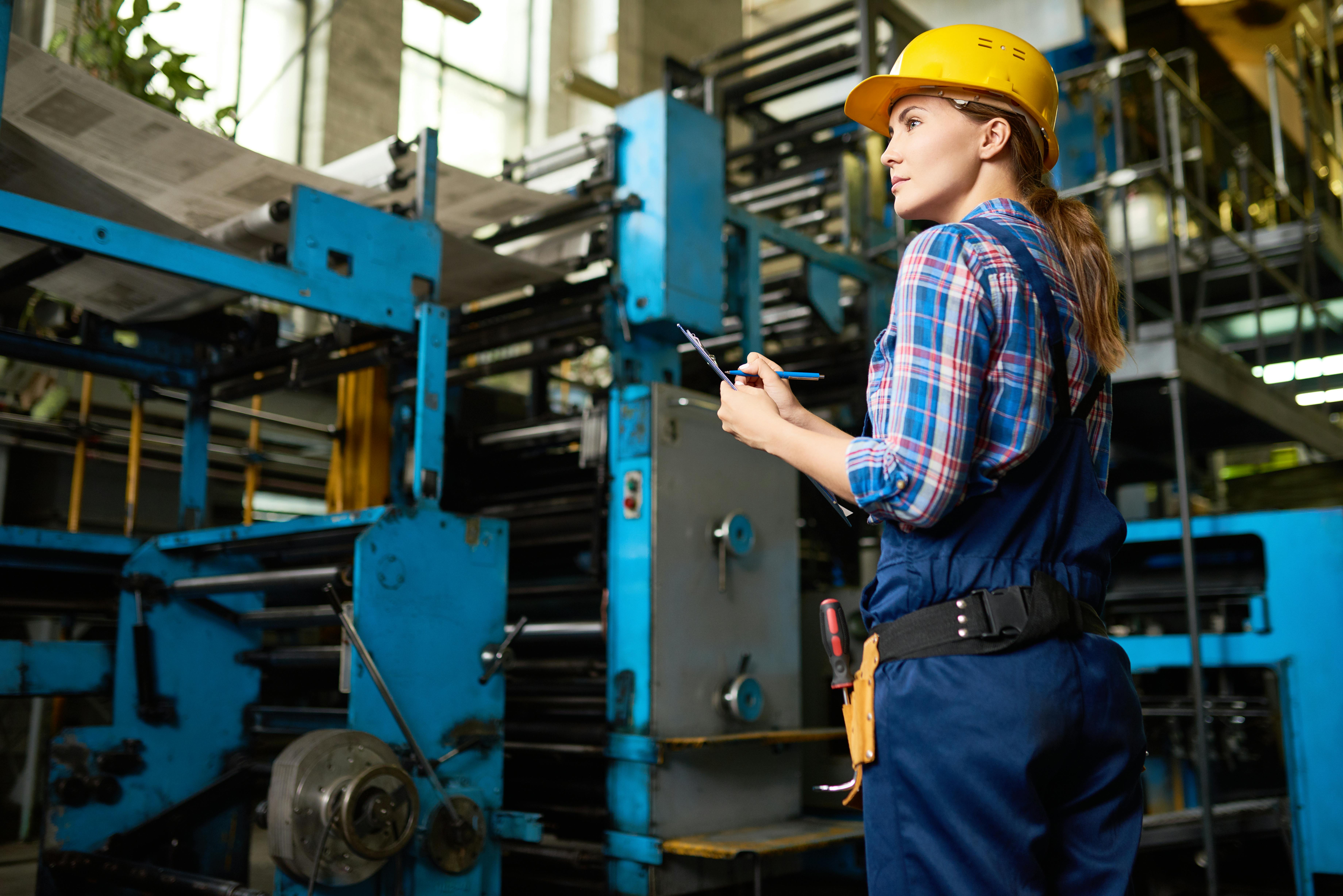 Young worker taking inventory at manufacturing plant