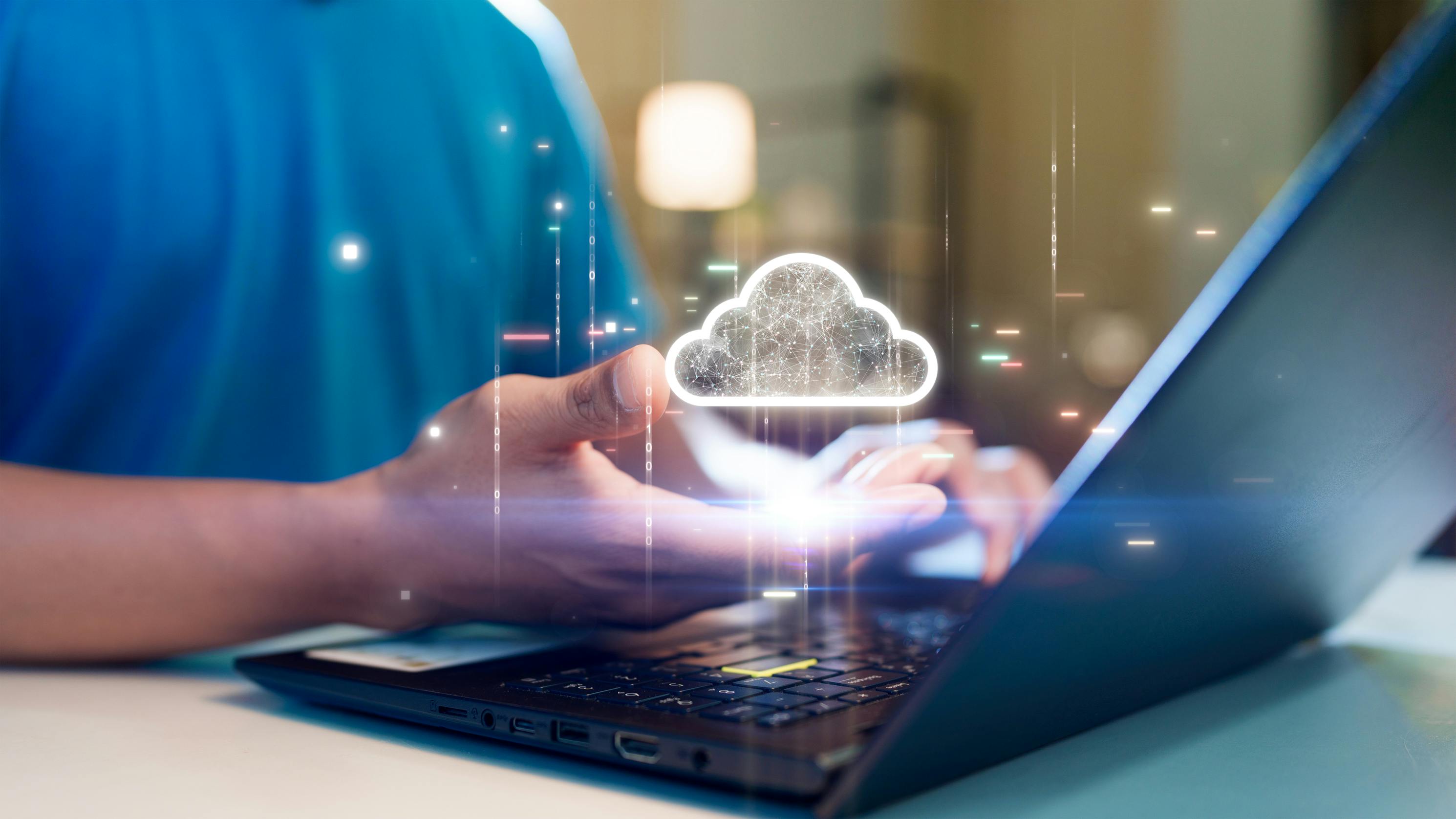 A Person Holding A Glowing Cloud Icon Above A Laptop, Symbolizing Cloud Computing, Data Storage, Or Digital Technology Concepts