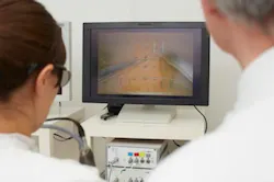 A surgeon practices sewing up a wound without a direct view. Doing so is more efficient with 3D screens. A surgeon practices sewing up a wound without a direct view. Doing so is more efficient with 3D screens.