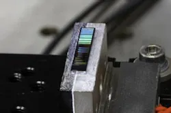 A silicon photonic chip is placed on a temperature-controlled stage; optical fibers (not shown) are used to couple an optical pump beam to the chip at one of the cleaved facets (left side of the chip), and to extract the generated photon pair from the cleaved facet at the right side of the chip. A silicon photonic chip is placed on a temperature-controlled stage; optical fibers (not shown) are used to couple an optical pump beam to the chip at one of the cleaved facets (left side of the chip), and to extract the generated photon pair from the cleaved facet at the right side of the chip.