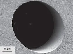FIGURE 2. An injection nozzle hole drilled with a high-power picosecond laser and helical drilling optics has sharp edges with no burr or melt and low surface roughness inside the hole. FIGURE 2. An injection nozzle hole drilled with a high-power picosecond laser and helical drilling optics has sharp edges with no burr or melt and low surface roughness inside the hole.
