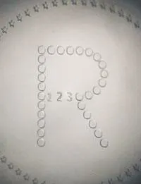 FIGURE 2. Eyeglass manufacturers use 193-nm excimer lasers to micro-encode their optics for tracking purposes. Here, the 'R' is 1.3 mm; the '1, 2, 3' digits are 0.10 mm in height. FIGURE 2. Eyeglass manufacturers use 193-nm excimer lasers to micro-encode their optics for tracking purposes. Here, the 'R' is 1.3 mm; the '1, 2, 3' digits are 0.10 mm in height.