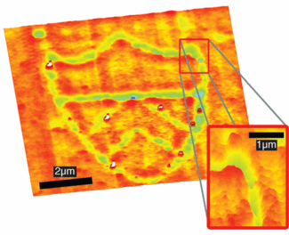 A 0.76-&micro;m-diameter microsphere confined in a Bessel-beam optical trap is used to focus laser illumination at a 355 nm wavelength onto a polyimide substrate. As the substrate is translated, a 5-&mu;m-wide Princeton University shield logo is written on the film directly under the trapped microsphere using overlapping pulses from the laser at a fluence of approximately 3 mJ/cm2. Surface features range from -30 to +10 nm.