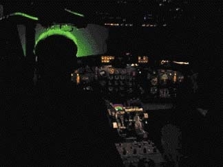 Laser illumination in a dark cockpit at 50-&micro;W/cm2 shows up from the rear as a green halo around subject's head.