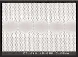 A scanning electron micrograph shows five coupled cavities situated in a photonic crystal; the entire structure of 40 cavities forms a laser. The brighter region straddling the hexagons defines the area where the pump current is injected, parallel to the microholes. A scanning electron micrograph shows five coupled cavities situated in a photonic crystal; the entire structure of 40 cavities forms a laser. The brighter region straddling the hexagons defines the area where the pump current is injected, parallel to the microholes.