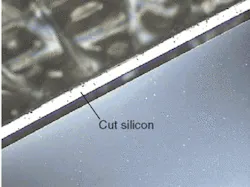 FIGURE 2. A 70-µm-thick wafer with an edge cut parallel to the edge of the wafer shows a thin ring of cut silicon about 50-µm wide that appears white in the photo. FIGURE 2. A 70-µm-thick wafer with an edge cut parallel to the edge of the wafer shows a thin ring of cut silicon about 50-µm wide that appears white in the photo.
