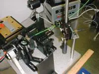 FIGURE 3. This diode-pumped erbium-doped fluoride glass fiber laser is being studied for microsurgical applications in ophthalmology and otolaryngology. The fiber-laser emission beam is shown incident on a laser power meter on the far left side of the photograph. FIGURE 3. This diode-pumped erbium-doped fluoride glass fiber laser is being studied for microsurgical applications in ophthalmology and otolaryngology. The fiber-laser emission beam is shown incident on a laser power meter on the far left side of the photograph.