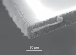 FIGURE 4. A SEM image shows increased debris and poor cut quality on the resultant die for “double pulse” irradiation at 4 m/s scan speed. FIGURE 4. A SEM image shows increased debris and poor cut quality on the resultant die for “double pulse” irradiation at 4 m/s scan speed.
