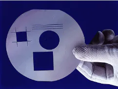 FIGURE 2. Trimming a semiconductor wafer with a silicon router machine is a typical laser micromachining application. FIGURE 2. Trimming a semiconductor wafer with a silicon router machine is a typical laser micromachining application.