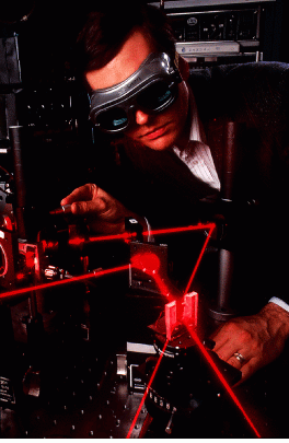The 'X' where the lasers cross marks the spot where IBM scientist W. E. Moerner is testing a polymer that exhibits the photorefractive effect. This new material may lead to the development of instant holographic cameras, optical data storage many times denser than today`s, and safety goggles that would instantly protect the wearer from being blinded by intense laser light.