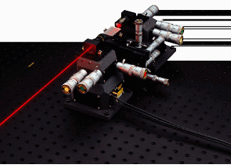 FIGURE 1. Four-axis manipulator positions a fiberoptic telecommunications waveguide between two three-axis stages for production quality testing. Coarse optics adjustments to within 50 nm are made with manual micrometers and are further refined by an order of magnitude with piezo actuators.