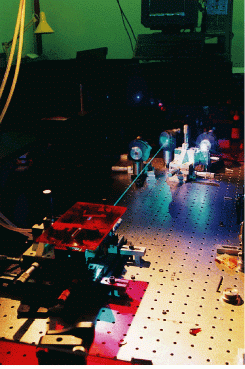FIGURE 1. Improved Ti:sapphire oscillator produces 120-mW second-harmonic violet-blue pulses, seen by their glow on the screen behind the optical table on which is mounted a Coherent (Santa Clara, CA) argon-ion laser pump.