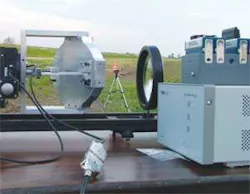 In a setup designed to test a space-elevator power-transmitting optical system, light from an LED on a distant tripod reflects off a mirror (left, facing away) to an image sensor (right). The resulting image data is processed to provide a signal that drives the mirror actuators, which in operation will keep the power-transmitting laser beam aligned to its target. In this test, the LED is moved farther down the road in the background out to 1 km to test system performance. In a setup designed to test a space-elevator power-transmitting optical system, light from an LED on a distant tripod reflects off a mirror (left, facing away) to an image sensor (right). The resulting image data is processed to provide a signal that drives the mirror actuators, which in operation will keep the power-transmitting laser beam aligned to its target. In this test, the LED is moved farther down the road in the background out to 1 km to test system performance.