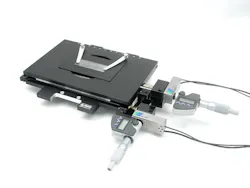 FIGURE 1. The MICI80-KMI53 microscopy stage from Piezosystem Jena, available in both open- and closed-loop versions, can be used for positioning or scanning with sub-nanometer resolution. The ultrastiff flexure design drives the digital micrometer heads with a resolution of 1 µm, a manual range of motion of 25 mm in the x-y axes, and a piezo-based range of motion of 80 µm. A proprietary frame design links the x-y axes in a single piece of metal for superior orthogonality and flatness. A special coil spring system delivers a constant force throughout the manual travel range of the stage, allowing preload optimization over the entire range of travel for extremely low drifting behavior. FIGURE 1. The MICI80-KMI53 microscopy stage from Piezosystem Jena, available in both open- and closed-loop versions, can be used for positioning or scanning with sub-nanometer resolution. The ultrastiff flexure design drives the digital micrometer heads with a resolution of 1 µm, a manual range of motion of 25 mm in the x-y axes, and a piezo-based range of motion of 80 µm. A proprietary frame design links the x-y axes in a single piece of metal for superior orthogonality and flatness. A special coil spring system delivers a constant force throughout the manual travel range of the stage, allowing preload optimization over the entire range of travel for extremely low drifting behavior.