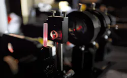 FIGURE 2. Phosphate laser glass is shown in an end-pumped laser cavity undergoing performance testing. FIGURE 2. Phosphate laser glass is shown in an end-pumped laser cavity undergoing performance testing.