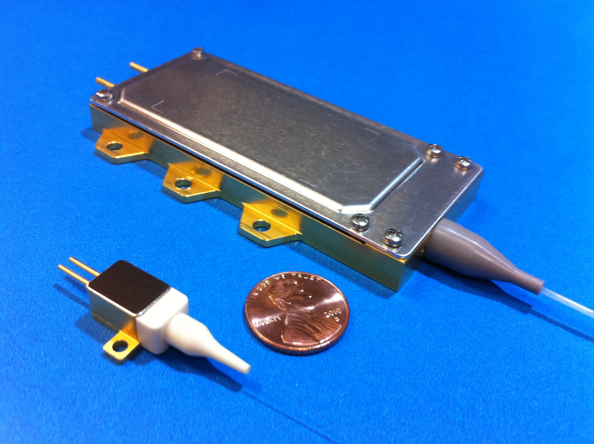FIGURE 1. A high-brightness 9XX nm fiber-coupled pump (top) produces 100 W from a 105-&micro;m-core-diameter, 0.15 NA fiber. A 10 W single emitter (bottom) is shown for size comparison.