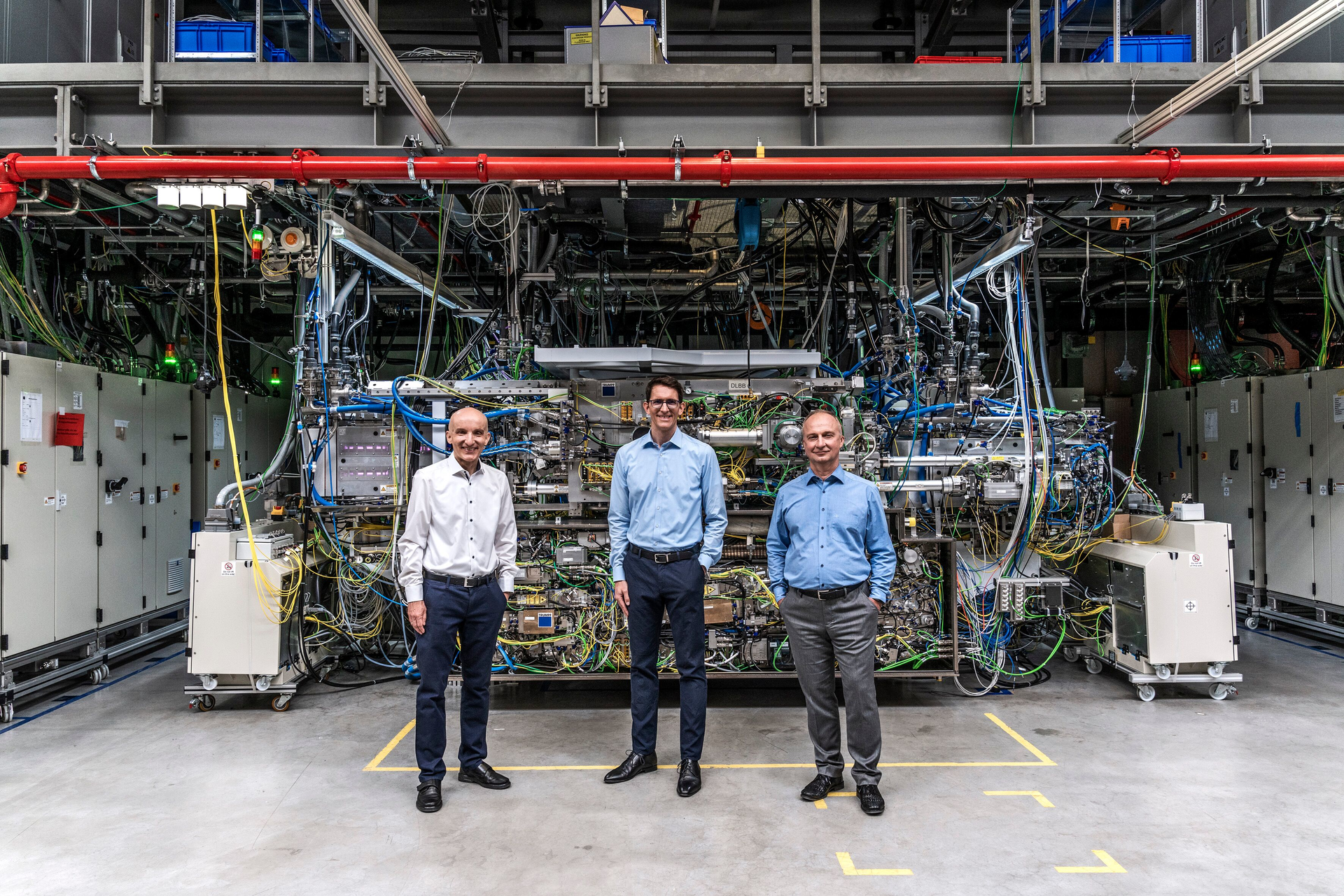 Standing in front of the world's strongest pulsed industrial laser are (L-R) Dr. Peter K&uuml;rz from ZEISS Semiconductor Manufacturing Technology (SMT); Michael K&ouml;sters from TRUMPF Lasersystems for Semiconductor Manufacturing; and Sergiy Yulin from Fraunhofer IOF. (Copyright: Deutscher Zukunftspreis/Ansgar Pudenz)