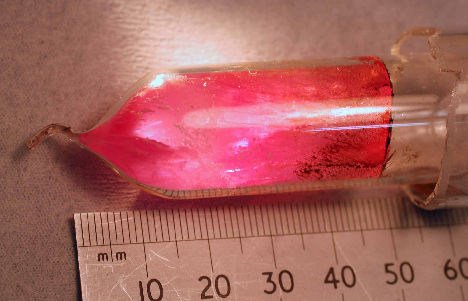 A pentacene-doped p-terphenyl crystal serves as the gain medium for a room-temperature solid-state maser. Here, the crystal boule is shown after doping, still sealed in the vial of borosilicate glass used to contain it during the doping procedure (a zone-refining operation that takes place in a furnace).