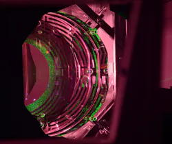 An Advanced LIGO optic has a mass of about 40 kg; about half of the cylindrical optic can be seen. The green light comes from an alignment laser. The maze-like patterns are actuators that translate, tip, and tilt the optic to maintain its alignment. An Advanced LIGO optic has a mass of about 40 kg; about half of the cylindrical optic can be seen. The green light comes from an alignment laser. The maze-like patterns are actuators that translate, tip, and tilt the optic to maintain its alignment.
