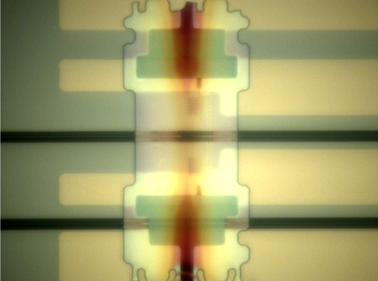 One of the MIT researchers' new photon detectors, deposited athwart a waveguide (horizontal black band) on a silicon optical chip.