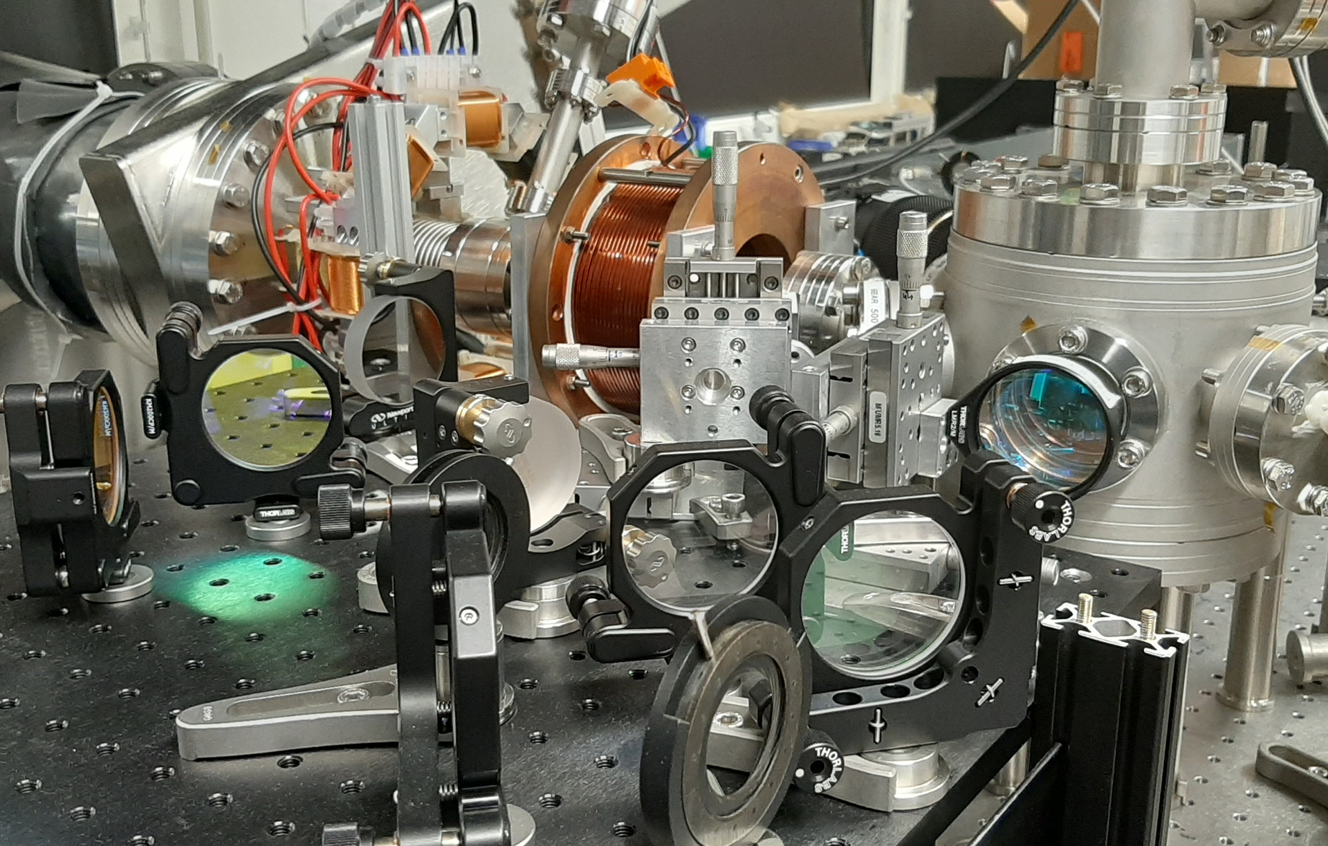 The electron beam travels from left to right and, in the cylindrical vacuum chamber on the right, laser-modulated into few-attosecond-long pulses by two-photon transitions.