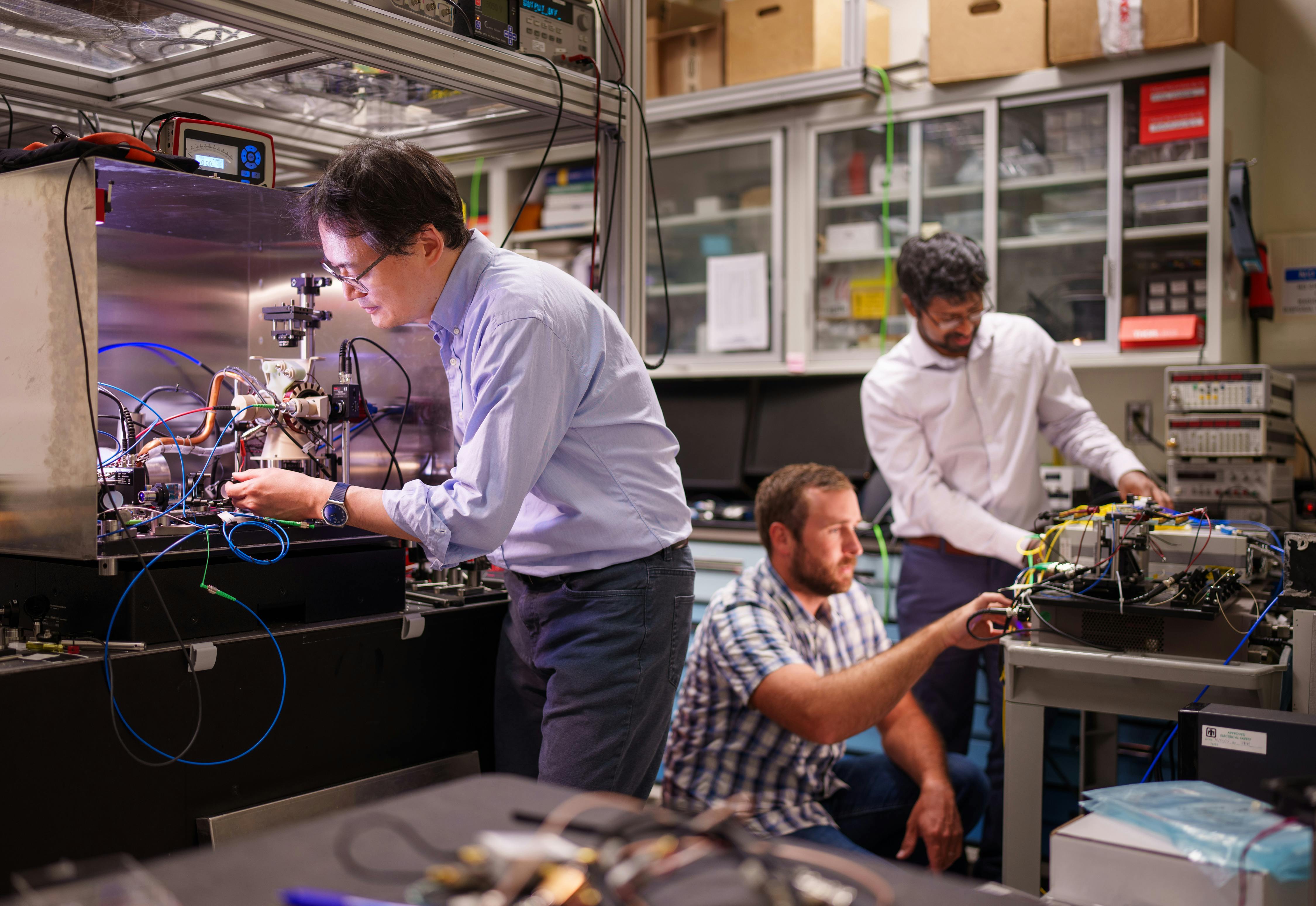 Sandia National Laboratories&rsquo; Scientist Jongmin Lee (left) prepares a rubidium cold-atom cell for an atom interferometry experiment while Scientists Ashok Kodigala (right) and Michael Gehl initialize the controls for a packaged single-sideband modulator chip.