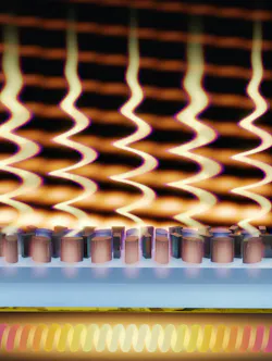 A thermal metasurface made of a single layer of nanostructured silicon (gray) atop glass (blue) and a metal mirror (gold). Its surface is tailored to thermally emit circularly polarized light in a desired direction. A thermal metasurface made of a single layer of nanostructured silicon (gray) atop glass (blue) and a metal mirror (gold). Its surface is tailored to thermally emit circularly polarized light in a desired direction.