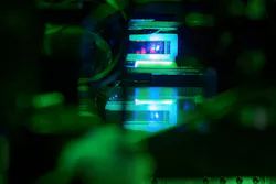 Glass cell with a cloud of laser-cooled strontium atoms hovering above a high-resolution microscope objective in our experiment at the Max Planck Institute of Quantum Optics. Glass cell with a cloud of laser-cooled strontium atoms hovering above a high-resolution microscope objective in our experiment at the Max Planck Institute of Quantum Optics.