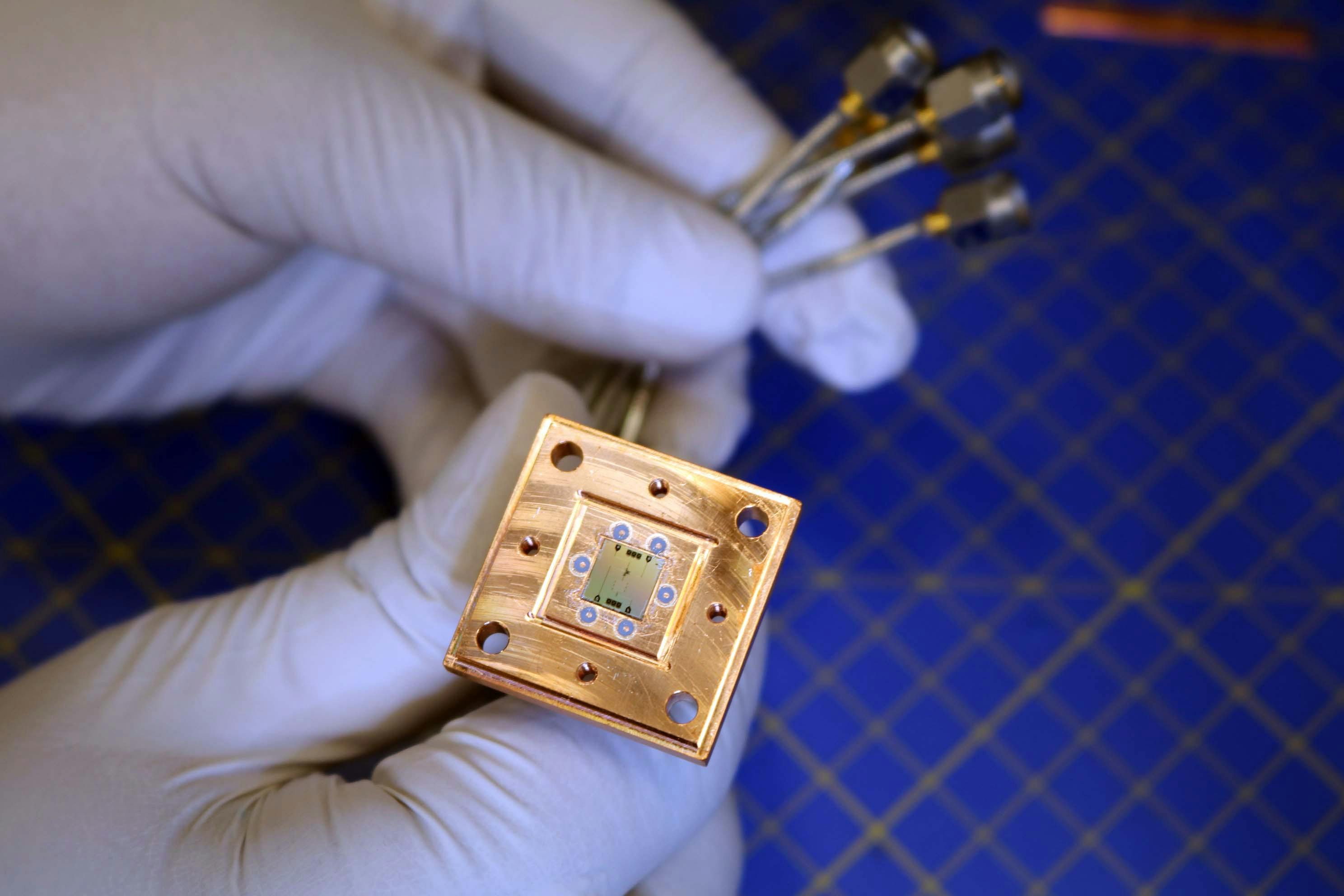 FIGURE 1. The new quantum refrigerator, visible as the square chip at the center of the copper enclosure, is built of superconducting qudits to cool a target superconducting qubit.