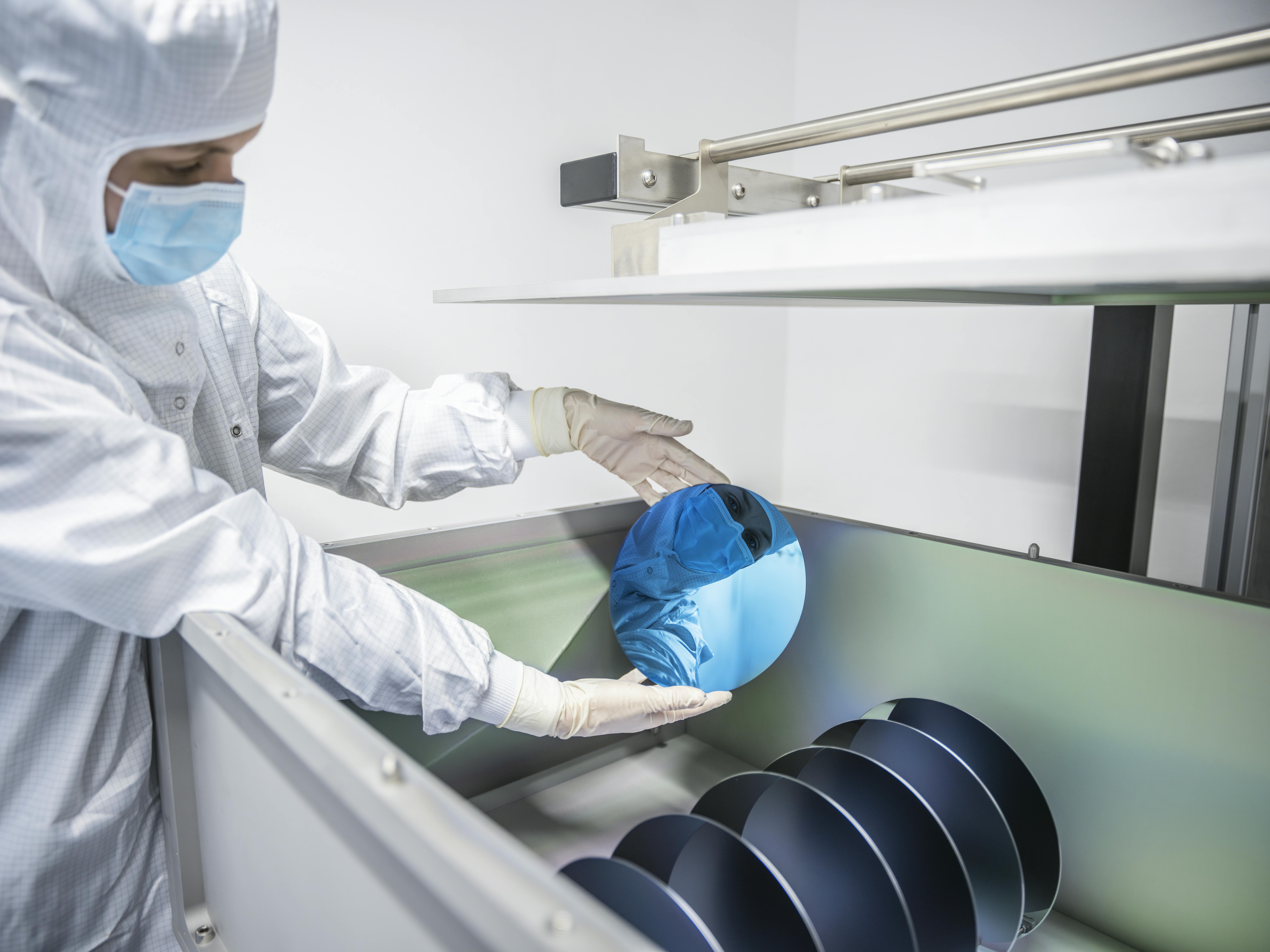 A researcher holds a highly reflective mirror for laser applications; the technology is being optimized for laser fusion.