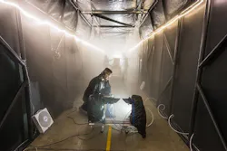 Image: Sandia National Laboratories developed a fog chamber to test optics, like security camera sensors, in a controlled environment. Sandia chemical engineer Andres Sanchez checks an instrument that measures the particle size and concentration of the fog in the chamber’s atmosphere. Image: Sandia National Laboratories developed a fog chamber to test optics, like security camera sensors, in a controlled environment. Sandia chemical engineer Andres Sanchez checks an instrument that measures the particle size and concentration of the fog in the chamber’s atmosphere.