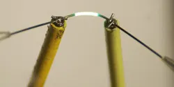 A fiber with a 500 nm diameter glows along a 5 mm length. A fiber with a 500 nm diameter glows along a 5 mm length.