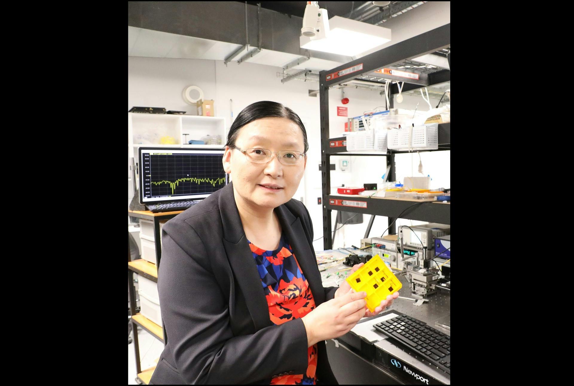 Professor Xiaoke Yi in the lab with her group&rsquo;s AI nanophotonic chip prototype.