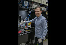 NIST scientist Nikolai Klimov holds a PIC with tweezers. NIST scientist Nikolai Klimov holds a PIC with tweezers.