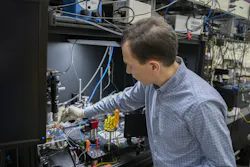 Nikolai Klimov is holding a plastic box that contains a PIC coupled to an optical fiber. Nikolai Klimov is holding a plastic box that contains a PIC coupled to an optical fiber.