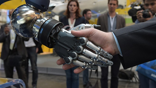 A robot shakes hands with a human at Hannover Messe 2015
