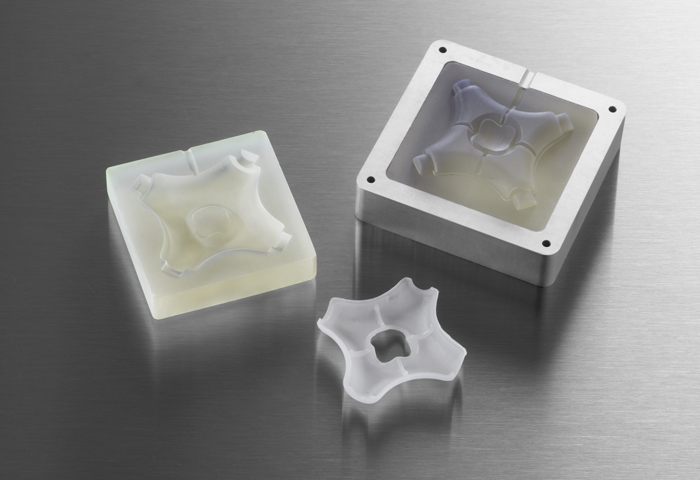 Moules d'injection imprimés en 3D dans un cadre en aluminium avec la pièce moulée par injection finie.