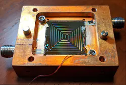 Two of NIST’s superconducting thermometers for measuring cryogenic temperatures are glued to the lower left and upper right of this amplifier. The miniature thermometers, made of niobium on a layer of silicon dioxide, measure the temperature of the amplifier or other device based on a frequency signal. Two of NIST’s superconducting thermometers for measuring cryogenic temperatures are glued to the lower left and upper right of this amplifier. The miniature thermometers, made of niobium on a layer of silicon dioxide, measure the temperature of the amplifier or other device based on a frequency signal.