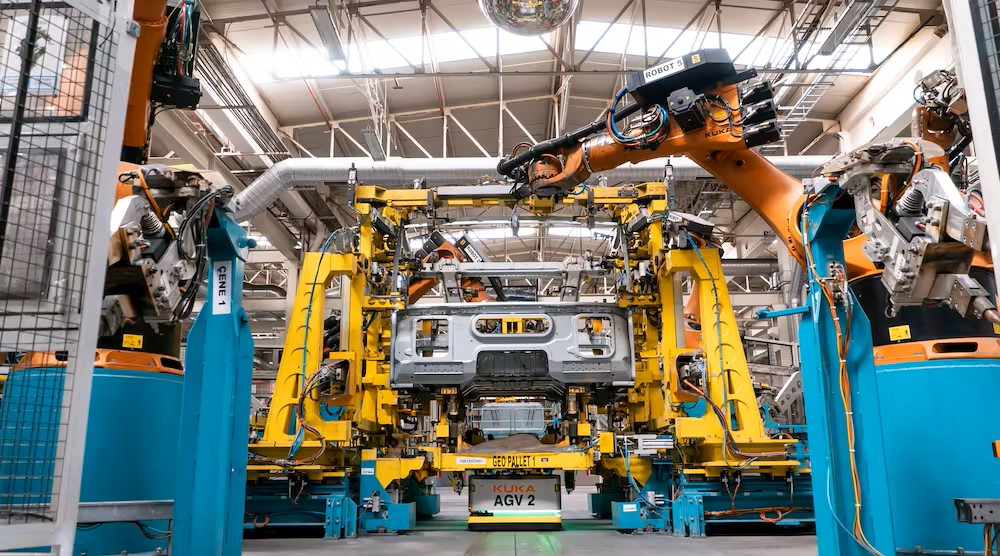 Mobile platforms transport truck cabins in and out of a welding cell.