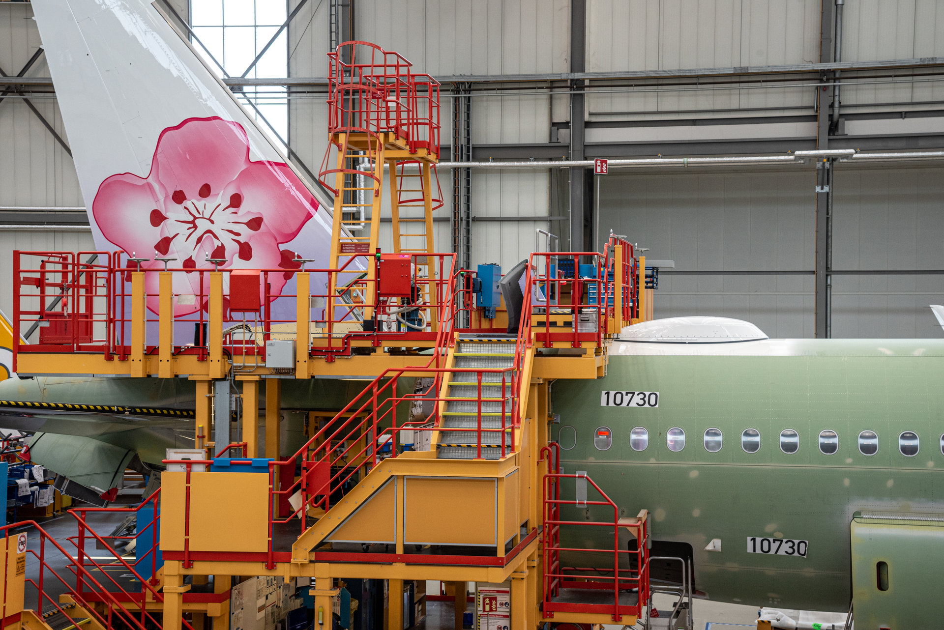 Airbus employees paint the tail emblem on China Airlines' A321neo prior to delivery.