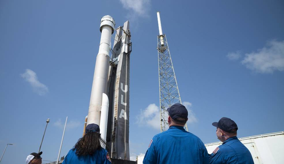 NASA astronauts Suni Williams, left, Barry 'Butch' Wilmore, center, and Mike Fincke, right, watch as a United Launch Alliance Atlas V rocket with Boeing&rsquo;s CST-100 Starliner spacecraft aboard is rolled out of the Vertical Integration Facility to the launch pad at Space Launch Complex 41 ahead of the Orbital Flight Test-2 (OFT-2) mission, Wednesday, May 18, 2022, at Cape Canaveral Space Force Station in Florida.